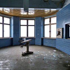 Runder, verlassener Raum mit blauen Fliesen.