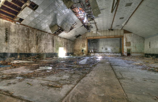 Einsturzgefährdete Halle mit kaputter Decke.
