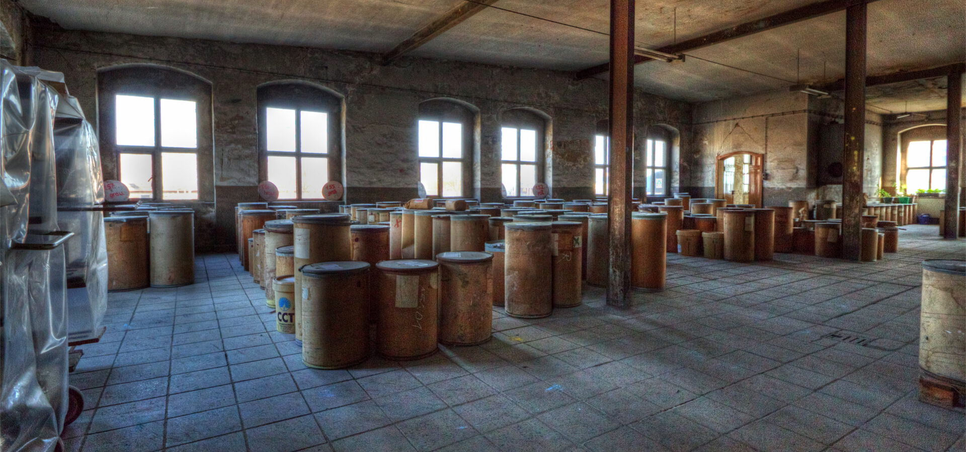 Lagerraum mit vielen Holzfässern und Fenstern.